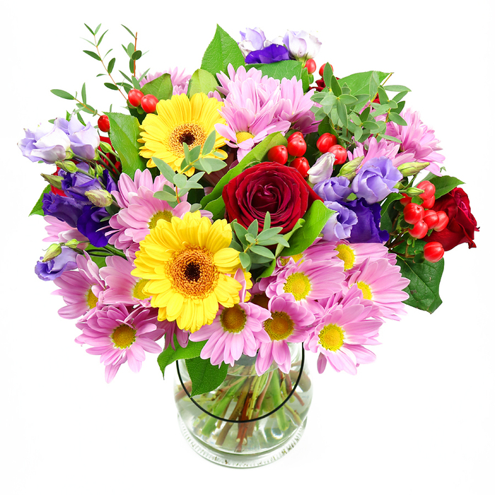 A tall, exuberant bouquet overflows from a clear glass vase, the arrangement photographed against a spotless white backdrop so that each flower stands out in vivid detail. Deep red roses form the emotional core, their velvety petals spiralling densely to create a sense of depth and intimacy. Just off-centre, yellow gerbera daisies with rich brown-orange centres beam like little suns, their smooth, broad petals catching the light and adding a confident brightness. Surrounding this heart of the bouquet, soft pink daisies or chrysanthemums cluster together, each bloom with a neat yellow eye and a ring of delicate, slender petals that lend the design a feathery softness. Winding through the pinks and yellows are the cooler tones of purple and lavender lisianthus; their bell-shaped blossoms and gently curled edges bring a graceful movement, as if the flowers were mid-sway in a light Garston breeze. Here and there, tight clusters of red hypericum berries punctuate the arrangement, glossy and round, offering a different texture that contrasts with the petals. The bouquet is richly framed with greenery, from deep, polished leaves to airy, light-green sprigs, echoing the layered foliage you might see walking past well-tended front gardens near central Garston. The glass vase itself is plain and elegant, revealing the carefully trimmed stems fanning out into clear water, a testament to expert preparation. Overall, the image conveys warmth, joy, and a thoughtful, modern style-an ideal mixed arrangement for birthdays, thank-you gestures, or to brighten a living room, ready to be delivered fresh to homes and offices across Garston.