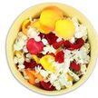 Seen from above, a smooth, round bowl in a soft cream and pale yellow shade is filled entirely with a lavish scattering of fresh petals, creating a gentle swirl of colour and texture. Most of the petals are unmistakably from roses, their broad, velvety surfaces layered in tones of deep crimson, glowing golden yellow, and muted peach-orange, like a warm sunset captured in floral form. Nestled throughout this colourful bed are small white florets, likely from delicate hydrangea blooms, each tiny petal forming part of a ruffled cluster that cools and lightens the arrangement. The petals touch and overlap, forming a plush, cushion-like surface that looks as though it would yield under your fingertips, releasing the soft, romantic scent of roses mingled with the fresher, cleaner fragrance of the white blossoms. Light falls gently across the bowl, picking out the curves, edges, and subtle shadows, giving the impression of depth and movement even though the composition is still. This kind of petal-filled bowl is often chosen as a tender funeral tribute in Garston-ideal for placing beside a coffin, on a memory table, or near a condolence book in a local chapel or funeral home. The colours communicate love, gratitude, and warmth, while the overall softness speaks of peace and rest. It feels like a quiet, contemplative detail, carefully arranged by an experienced Garston florist to support families through a final farewell with grace and beauty.